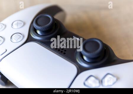 BRECHT, BELGIO – AGOSTO 14 2022: Primo piano dei bastoncini di un controller base per playstation 5 bianco che si ricarica con la USB-C ufficiale Foto Stock