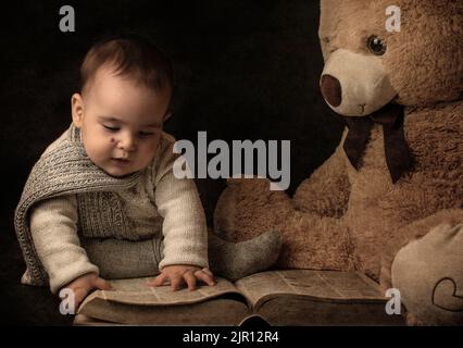 bambino di sette mesi che indossa un scarf lettura a orsacchiotto. Immagini del libro Dreammy Foto Stock