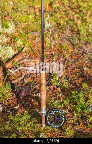 Pesca a mosca canna in piedi sul terreno Foto Stock