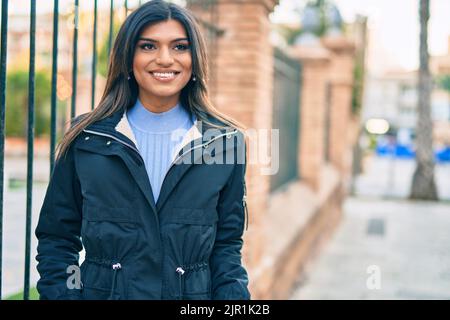 Bella donna ispanica sorridente confidente in città Foto Stock