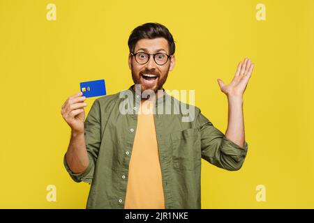 Overjoyed uomo di mezza età che tiene la carta di credito e sorridente alla macchina fotografica, cliente maschio che fa pubblicità ai servizi bancari Foto Stock