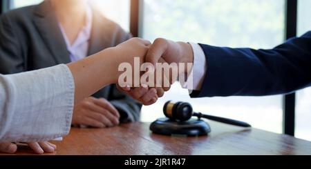 Uomini d'affari che scuotono la mano per sigillare un affare con i suoi avvocati o avvocati partner che discutono di un accordo contrattuale. Foto Stock