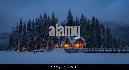 Crepuscolo mattutino presso l'iconico Emerald Lake Lodge del Parco Nazionale di Yoho con il Cilantro Cafe che si accende nell'alba ghiacciata. Foto Stock