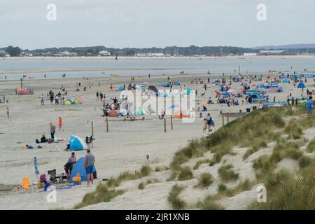 Tempo in Gran Bretagna, West Sussex, 21 agosto 2022: Nuvole, pioggia e alti di 21 gradi non scoraggia gli escursionisti con e senza cani, calciatori e pagaia da godersi la spiaggia di West Wittering. A differenza di altre spiagge del Sussex, l'acqua non è fuori limite, in quanto non ci sono stati scarichi di acque reflue locali. Nonostante la nuvola bassa e la pioggia intermittente, ci sono vedute dell'Isola di Wight e una regata nel Solent. Anna Watson/Alamy Live News Foto Stock