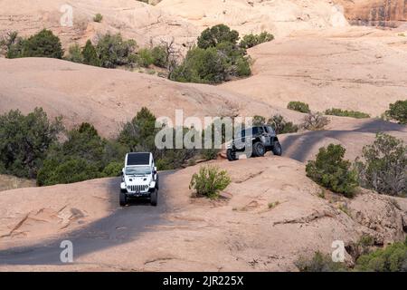 Due jeep in un tour sulla Jeep Trail Fins and Things sulla pietra arenaria Navajo nell'alto deserto vicino a Moab, Utah. Foto Stock