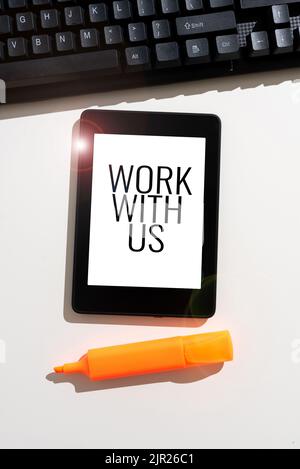 Scrittura a mano segno lavorare con noi. Foto concettuale invito a entrare a far parte di un'istituzione aziendale del team di lavoro messaggio importante presentato su Tablet on Desk Foto Stock