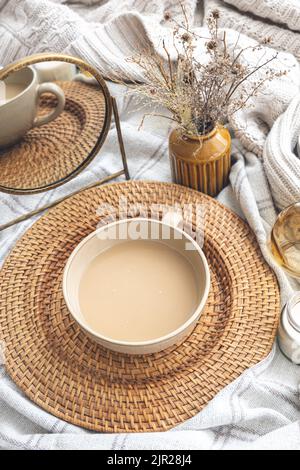 Composizione autunnale accogliente con una tazza di caffè e candele a letto. Foto Stock
