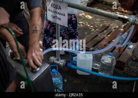 Mykolaiv, Ucraina. 19th ago, 2022. Un residente riempie le bottiglie d'acqua in una stazione di approvvigionamento di acqua come il conchiglie ha interrotto l'approvvigionamento principale di acqua nella città di Mykolaiv, Ucraina. Mykolaiv, la città strategica dell'Ucraina situata sul lato meridionale con accesso al Mar Nero ed è uno dei principali centri di costruzione navale, ha una popolazione di 476.101 abitanti (2021 est.), ma è stato sottoposto a un pesante assedio e bombardamento dopo l'invasione su larga scala dalla Russia. Come i funzionari ucraini hanno sostenuto la parzialità per recuperare il loro territorio, e di operare una contro-offensiva nel sud compreso Foto Stock