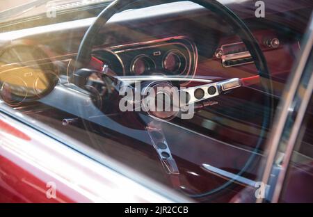 Volante e parte dell'interno di un'auto sportiva americana attraverso il finestrino. Primo piano. Foto Stock