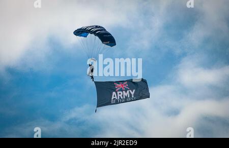 Un membro della squadra del Tigers Army Parachute Display vola una bandiera che dice 'Army Be the Best' mentre arriva a terra all'annuale Eastbourne Airshow, ON Foto Stock