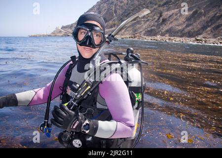 Il subacqueo, Bonnie Zaleski, si prepara ad entrare in una foresta di kelp al largo dell'isola di Catalina, California, Stati Uniti. Foto Stock