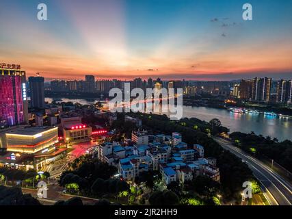 Sera città lungo il fiume edifici scena notturna a Nanning, Guangxi, Cina Foto Stock