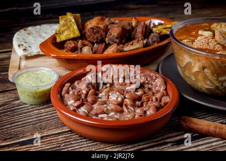 Varietà di cibo tradizionale colombiano con fagioli, picada, zuppa trippa, arepas e avocado Foto Stock