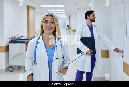 occupazione medica. Bella donna medico di medicina generale con la cartella clinica del paziente nelle sue mani in piedi in una clinica medica, ritratto Foto Stock