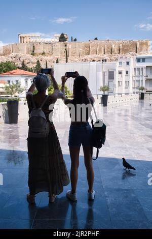 I turisti scattano foto dell'Acropoli dalla terrazza del Museo dell'Acropoli di Atene Foto Stock