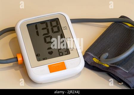 Monitor digitale automatico della pressione sanguigna con bracciale. Foto Stock
