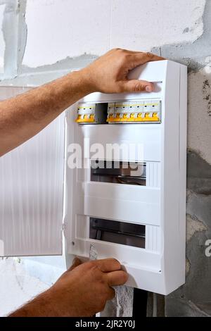 Installazione di una scatola elettrica interna in plastica o di un armadio nel locale di servizio della casa. Foto Stock