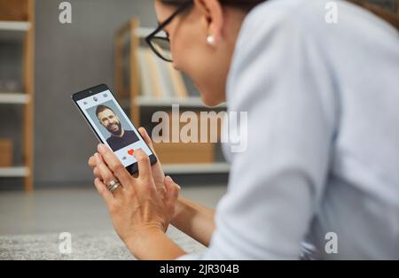 Donna felice soddisfatto che sfiorano e gradisca i profili sul luogo o sull'applicazione di rapporto. Foto Stock