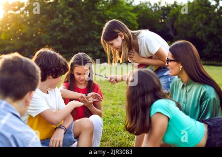 Gruppo di bambini felici che giocano, ballano e si divertono nel parco Foto Stock