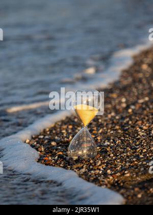 Clessidra sulla spiaggia in riva al mare Foto Stock