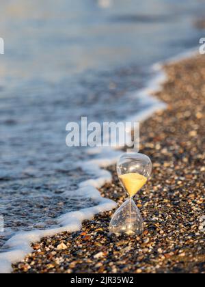 Clessidra sulla spiaggia in riva al mare Foto Stock