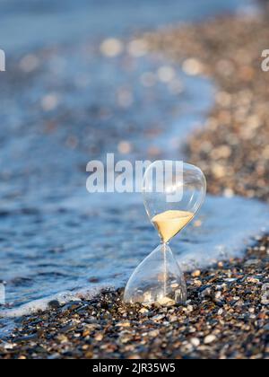 Clessidra sulla spiaggia in riva al mare Foto Stock