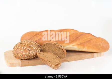 Baguette di grano e panino integrale su un tagliere isolato su bianco Foto Stock