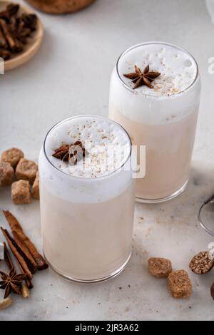 Latte di chai ghiacciato con spezie invernali calde sormontato da schiuma di latte Foto Stock