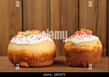 Kulich, pane dolce di lievito di pasqua russo decorato con glassa su sfondo di legno con spazio Foto Stock