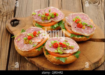 Sandwich al prosciutto con peperoncino, prezzemolo e scalogno su asse di legno orizzontale Foto Stock