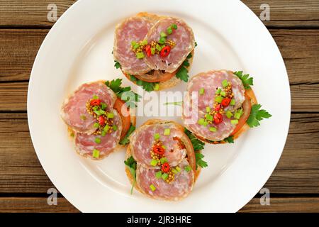 Sandwich al prosciutto con peperoncino, prezzemolo e scalogno sul piatto bianco vista dall'alto orizzontale Foto Stock