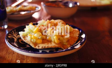 cibo messicano locale, crostada di mais con cetriolo, in piatto di ceramica fatto a mano con polvere piccante Foto Stock