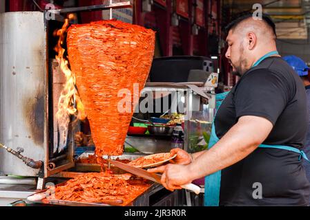 Fornitore di cibo che prepara carne al pastor al mercato Lucas de Galvez, Merida, Yucatan, Messico Foto Stock