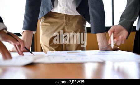 Un uomo d'affari professionale o un capo maschio conduce la riunione finanziaria con il suo team, discutendo e brainstorming dati finanziari sul rapporto. Ritagliato Foto Stock