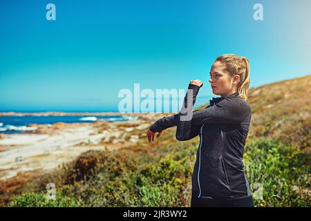 Stretch, esercizio fisico, corsa e relax. Una giovane donna sportiva che si stretching prima del suo allenamento all'aperto. Foto Stock