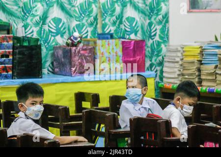 Gli studenti delle scuole elementari siedono all'interno della loro classe prima della loro prima classe. Le Filippine iniziano le lezioni di persona dopo 2 anni di scuola virtuale a causa della pandemia. Il Dipartimento dell'Educazione (DepEd) ha detto che ci sono 27.691.191 studenti iscritti per l'anno scolastico 2022-2023. Il 19% degli studenti nelle Filippine è completamente vaccinato e il 20% ha ricevuto solo la prima dose di vaccino COVID-19, ha affermato DedePed. Il protocollo del reparto è, se ci sono casi di COVID-19 o alcuni studenti che avvertono sintomi simil-influenzali, definitivamente si sposteranno dalle classi in-persona di nuovo al lear mescolato Foto Stock