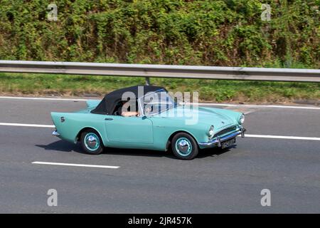 1960 60s Sessanta verde blu Sunbeam Alpine 1592cc benzina; viaggiando sull'autostrada M6 UK Foto Stock