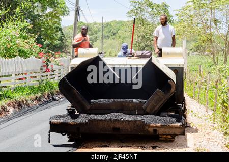 Uomini su asfalto macchina riparazione strada in Giamaica Foto Stock