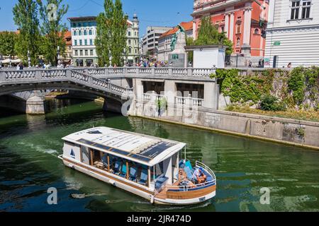 Lubiana, Slovenia - 13 luglio 2022: Tour in barca al Ponte triplo sul fiume Lubiana nel centro della città, crociera turistica sul fiume. Foto Stock