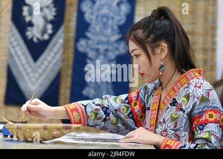 (220822) -- GUIYANG, 22 agosto 2022 (Xinhua) -- Zhang Juanjuan realizza una pittura batik in uno studio batik DIY ad Anshun, nella provincia di Guizhou, nel sud-ovest della Cina, 18 agosto 2022. Zhang Juanjuan, una ragazza del gruppo etnico di Miao, ha deciso di tornare a casa per prendere il controllo dei suoi genitori affari relativi ai prodotti batik fare dopo la laurea. Batik è un patrimonio culturale immateriale nella sua città natale. Ha registrato il laboratorio di batik dei suoi genitori come una società d'arte batik, e ha fondato il suo studio batik DIY. Per espandere la propria attività, Zhang Juanjuan e i suoi colleghi hanno progettato pratiche, rispettosi dell'ambiente, e. Foto Stock