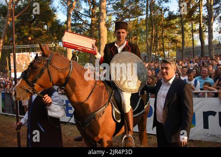 Barban, Croazia, 22 agosto 2022. Vincitore del torneo Race of the Ring, un cavaliere Petar Bencic posa per foto con il presidente della Repubblica di Croazia Zoran Milanovic a Barban, Croazia, il 22 agosto 2022. La corsa dell'anello è un gioco del cavaliere in cui il cavaliere deve attraversare il percorso lungo 150 metri e con una lancia colpire l'anello costituito da due cerchi concentrici interconnessi in modo che ci siano quattro campi tra loro. Il primo record della gara sul ring risale al 1696. A quel tempo fu organizzato dalla famiglia veneziana Loredan durante le fiere del villaggio di barba Foto Stock