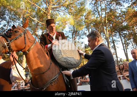 Barban, Croazia, 22 agosto 2022. Vincitore del torneo Race of the Ring, un cavaliere Petar Bencic posa per foto con il presidente della Repubblica di Croazia Zoran Milanovic a Barban, Croazia, il 22 agosto 2022. La corsa dell'anello è un gioco del cavaliere in cui il cavaliere deve attraversare il percorso lungo 150 metri e con una lancia colpire l'anello costituito da due cerchi concentrici interconnessi in modo che ci siano quattro campi tra loro. Il primo record della gara sul ring risale al 1696. A quel tempo fu organizzato dalla famiglia veneziana Loredan durante le fiere del villaggio di barba Foto Stock