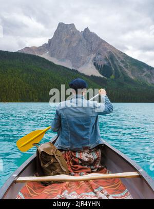 Emerald Lake in autunno al Parco Nazionale di Yoho Alberta Canada, uomini del lago Emerald Canada. Giovani con cappello in canoa al lago Foto Stock