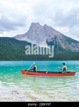 Emerald Lake in autunno al Parco Nazionale di Yoho Alberta Canada, uomini del lago Emerald Canada. Coppia di uomini e donne in canoa al lago durante una vacanza in Canada Foto Stock