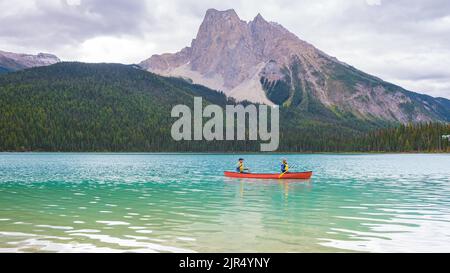 Emerald Lake in autunno al Parco Nazionale di Yoho Alberta Canada, uomini del lago Emerald Canada. Coppia di uomini e donne in canoa al lago durante una vacanza in Canada Foto Stock