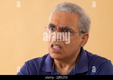 Primo piano ritratto di un uomo anziano arrabbiato che guarda altrove Foto Stock