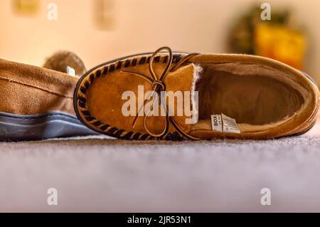 Un primo piano / primo piano di un paio di mocassini da uomo, sdraiati in un tappeto di colore beige / colorato. Foto Stock