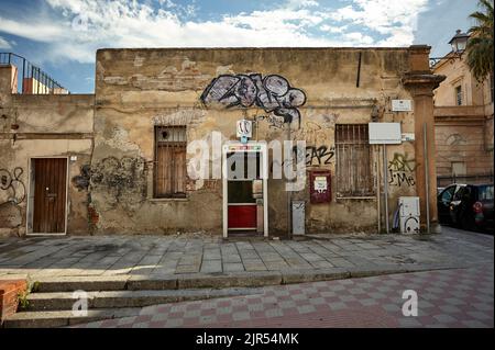 Piccolo edificio in decadimento coperto di graffiti preso in un vicolo nella città di Cagliari in Sardegna, Italia. Foto Stock