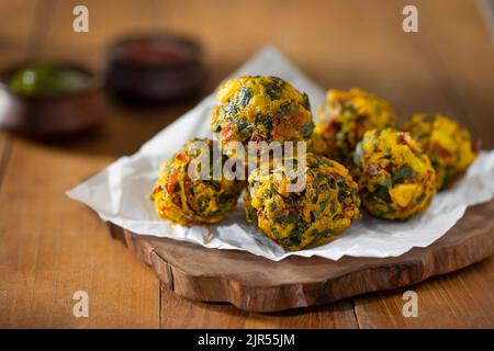 VERDURE FRITTE E PAKORAS SERVITE SU UN PIATTO DI LEGNO Foto Stock
