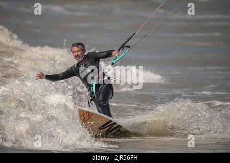 Kite surfeur dans la houle sur la plage d'Onival, mer formée et vent en baie de Somme. Foto Stock